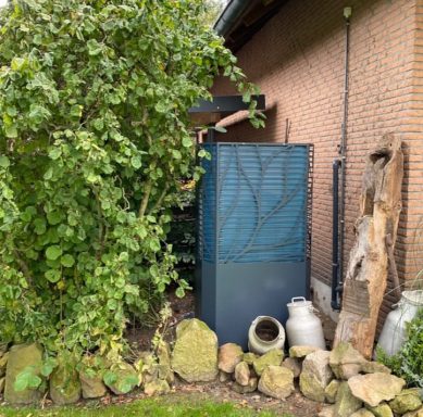 Ein blauer Schrank neben einer Pflanzenwand und einer Steinmauer.